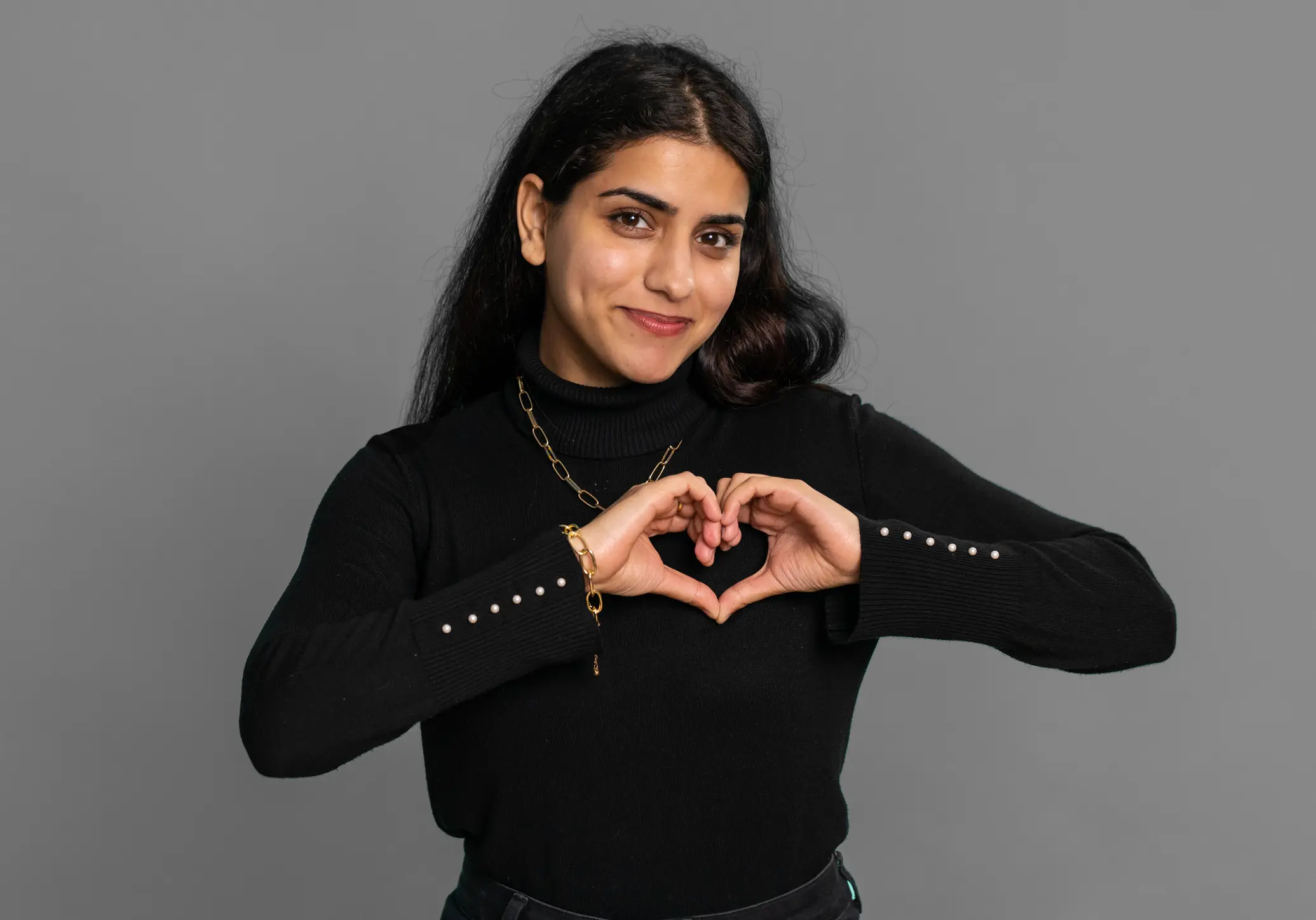 A woman making a heart shape with her hands